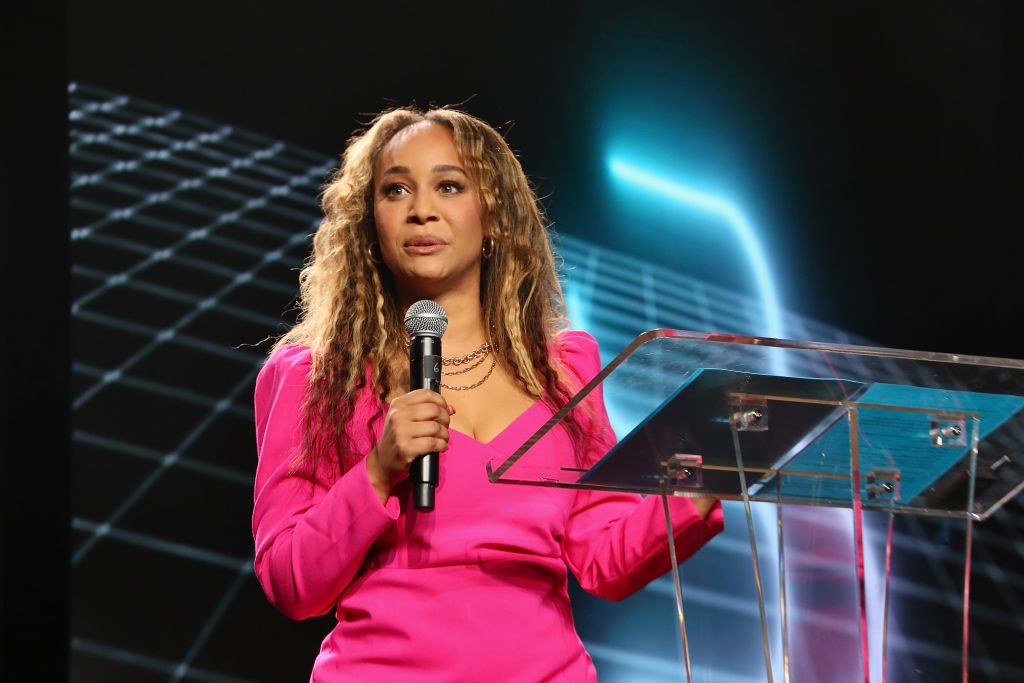 Morgan DeBaun speaking into a microphone behind a clear podium at AfroTech