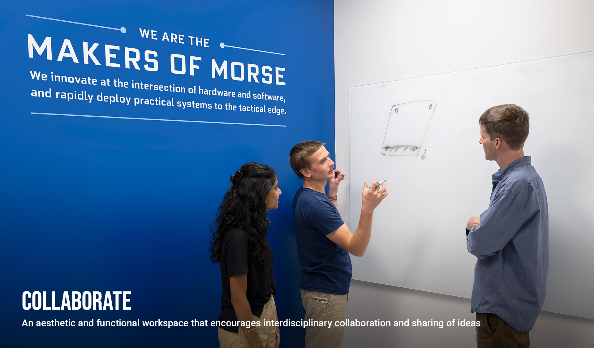 Three MORSE colleagues discussing a diagram at a whiteboard