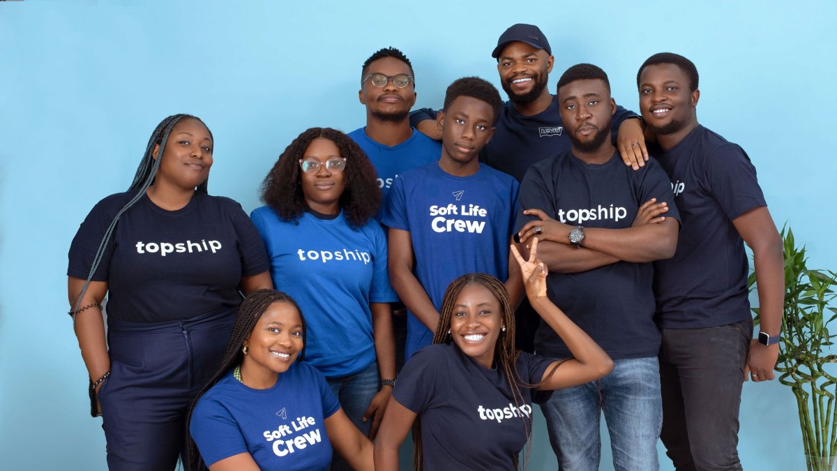 The Topship team in blue and navy shirts posing together against a blue background