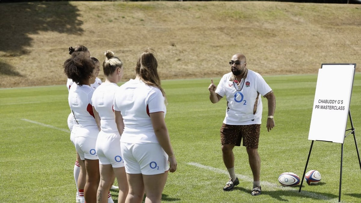 Chabuddy G holds a comic PR masterclass with England Red Roses players on a rugby pitch