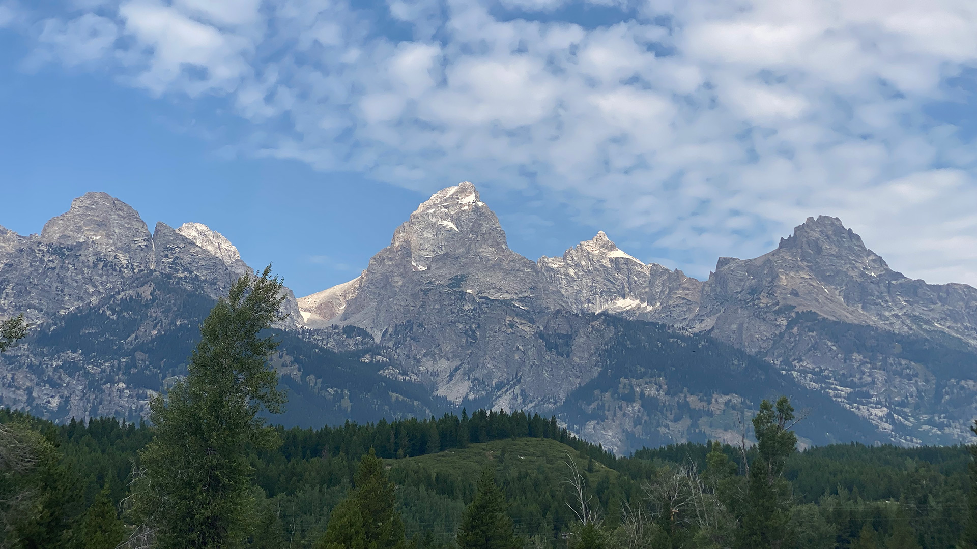 Mountain peaks above a reflective lake, the landscape used as the background on MST’s website