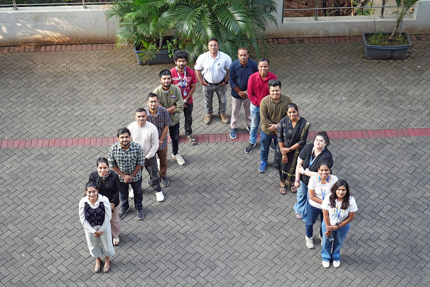 Aziro employees standing outdoors in two diagonal lines that form the company mark