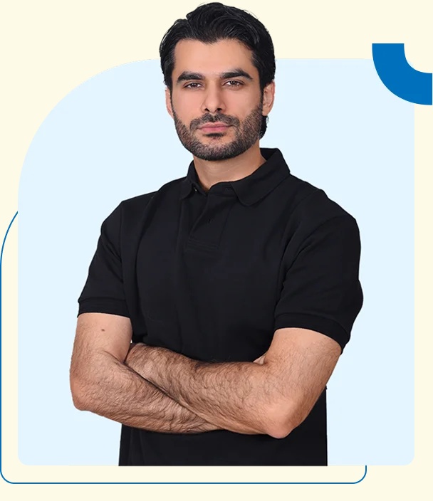 Mubashir Hanif in a black polo shirt, arms folded