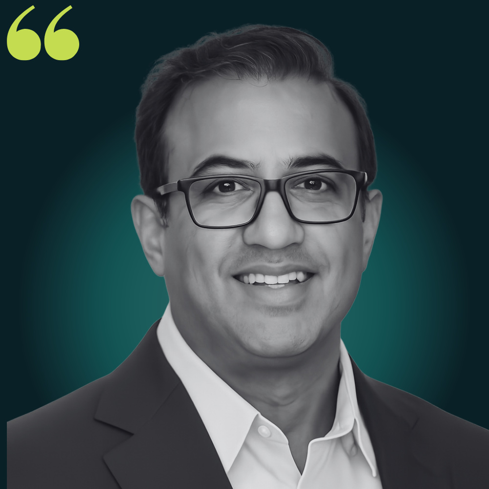 Editorial portrait of Muhammad Haq in a suit and glasses