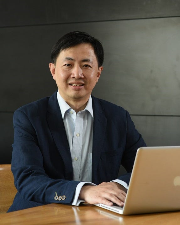 Mun Yew Wong seated at a table with an open laptop