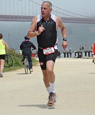Myers-Holum co-founder Mark Myers running beside the water, as pictured on the company leadership page