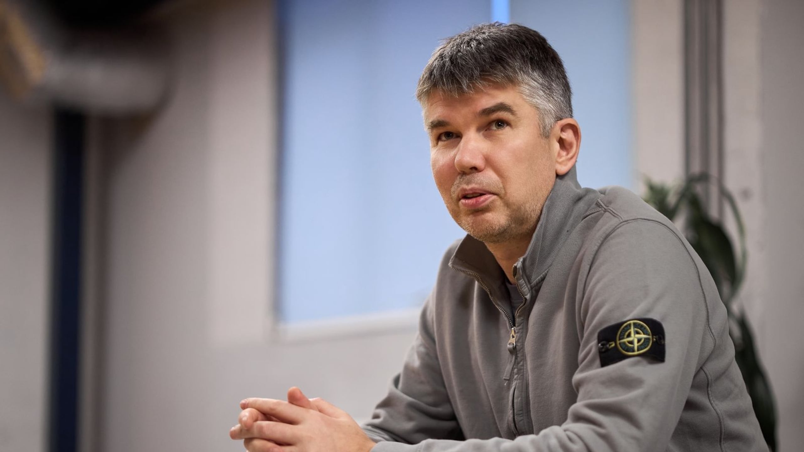 Mykola Paliienko seated in conversation, wearing a grey jacket