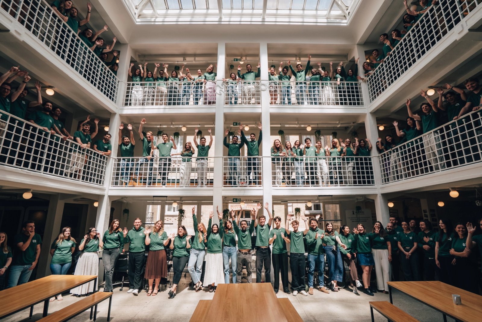Naboo team members in green shirts gathered on office balconies