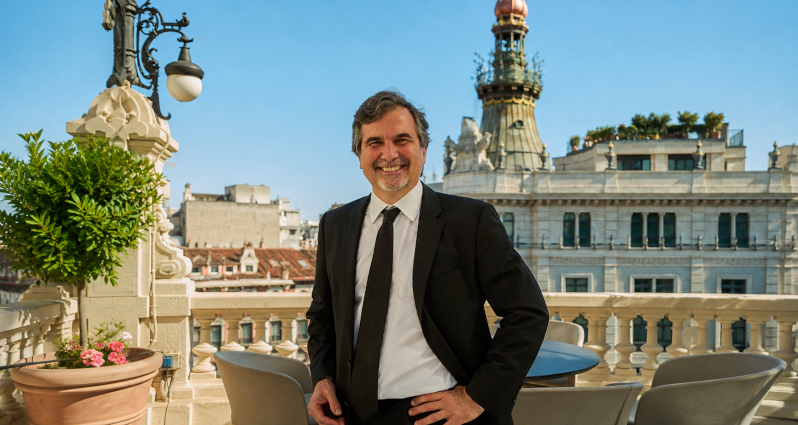 Nacho de Pinedo smiling on a rooftop terrace in Madrid, wearing a dark suit