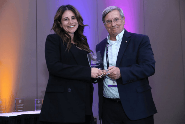 Nadia Khan accepting the 2023 TVNewsCheck Women in Technology Women to Watch award on stage