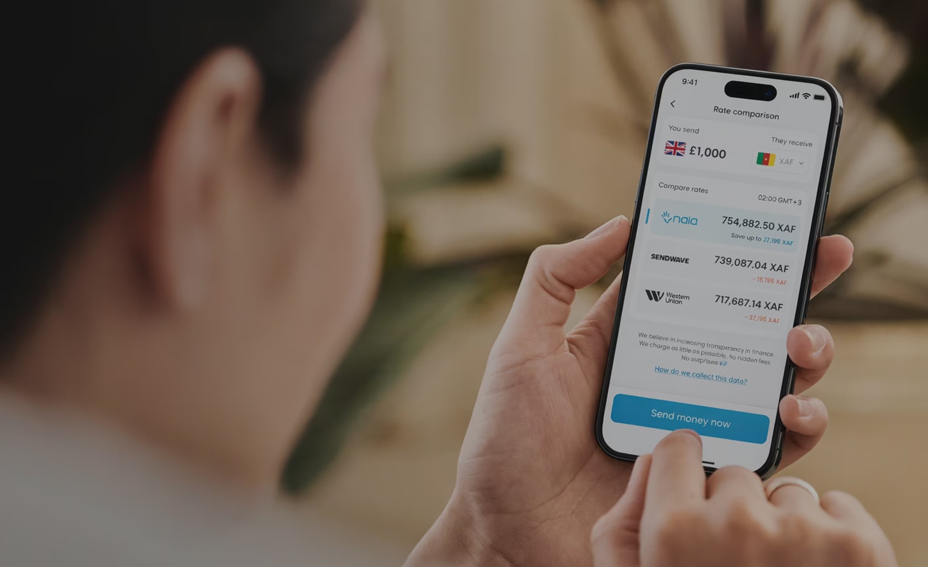 A hand holding a phone displaying the NALA transfer app