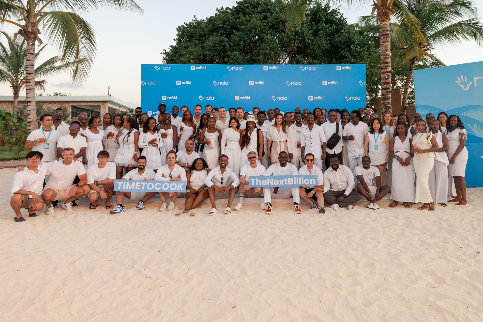 NALA and Rafiki colleagues gathered outdoors beneath palm trees