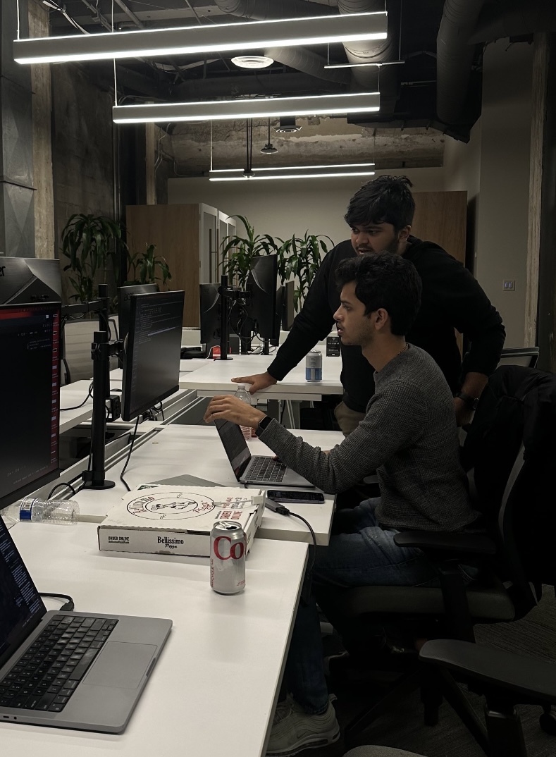 Naman Ambavi and Ayush working together at computers in a San Francisco office