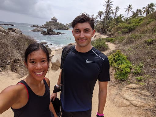 Nas Radev outdoors beside a companion, with a rocky coastline behind them