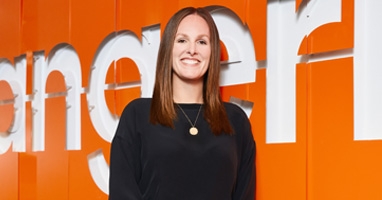Natalie Jones standing in front of Tangerine's orange wordmark