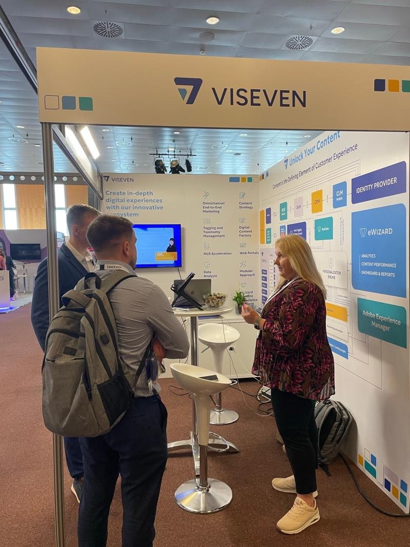 Nataliya Andreychuk speaking with visitors at a Viseven conference booth