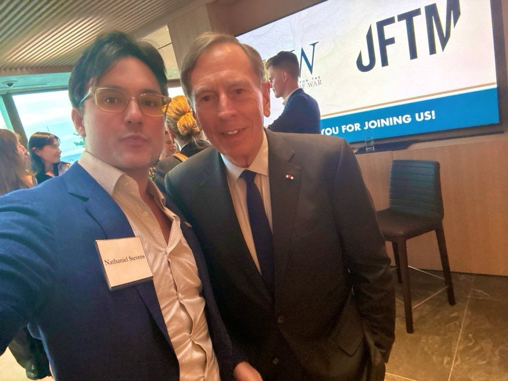 Nathaniel Stevens, left, wearing a name badge at an event with another attendee