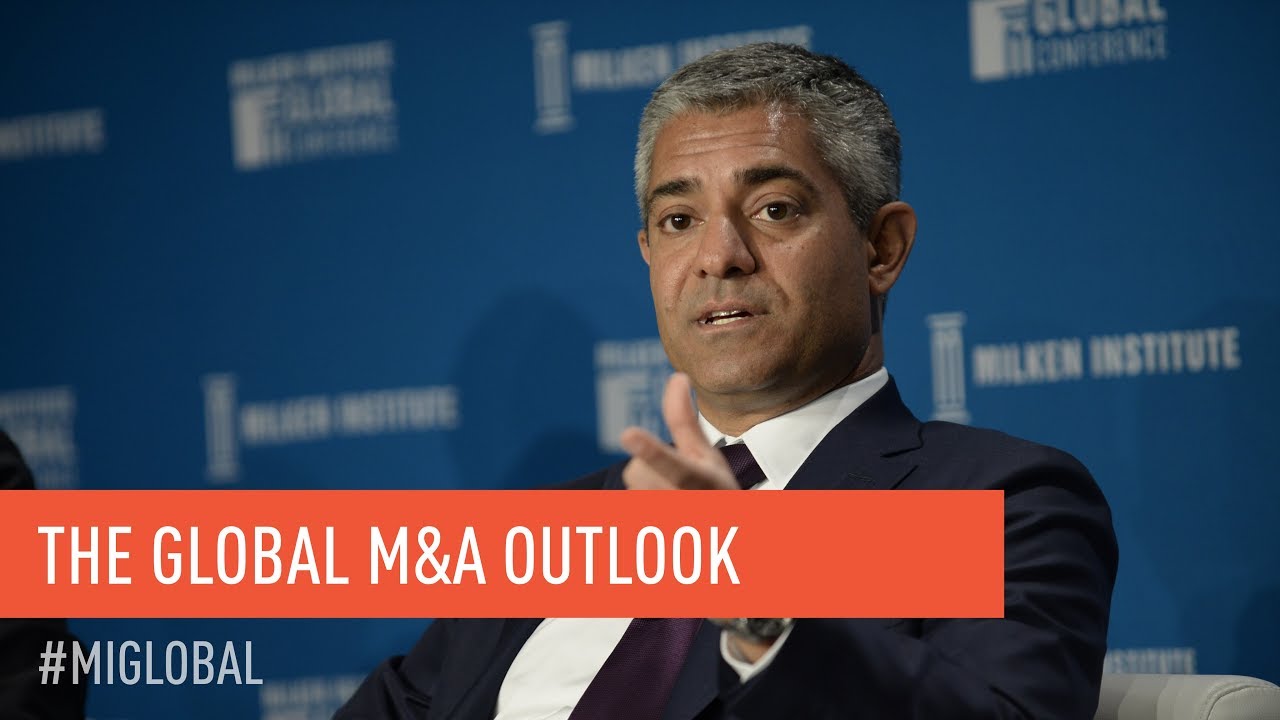 Navid Mahmoodzadegan speaking onstage in the Milken Institute’s The Global M and A Outlook video