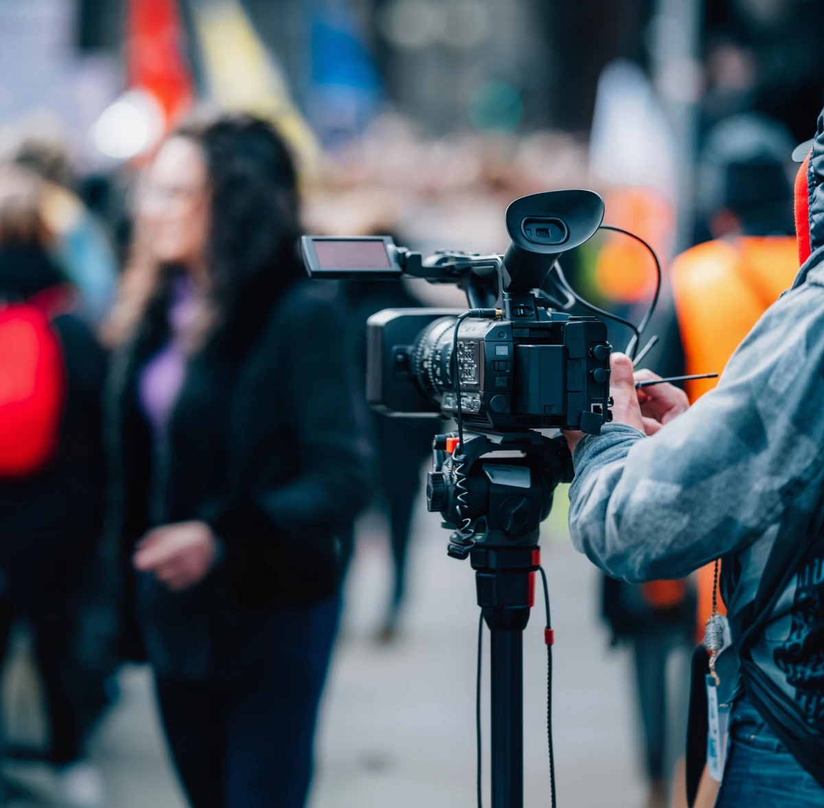 A camera operator filming an outdoor interview