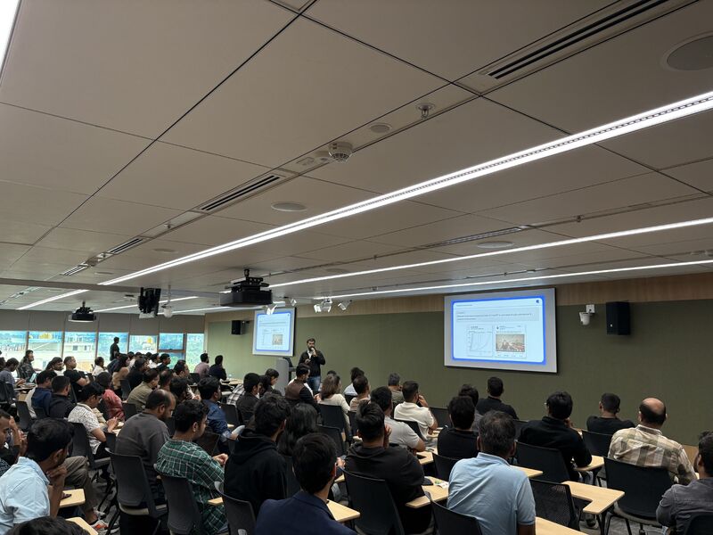 Nayrhit Bhattacharya speaking at the front of a seated audience during an AI event at Google's office