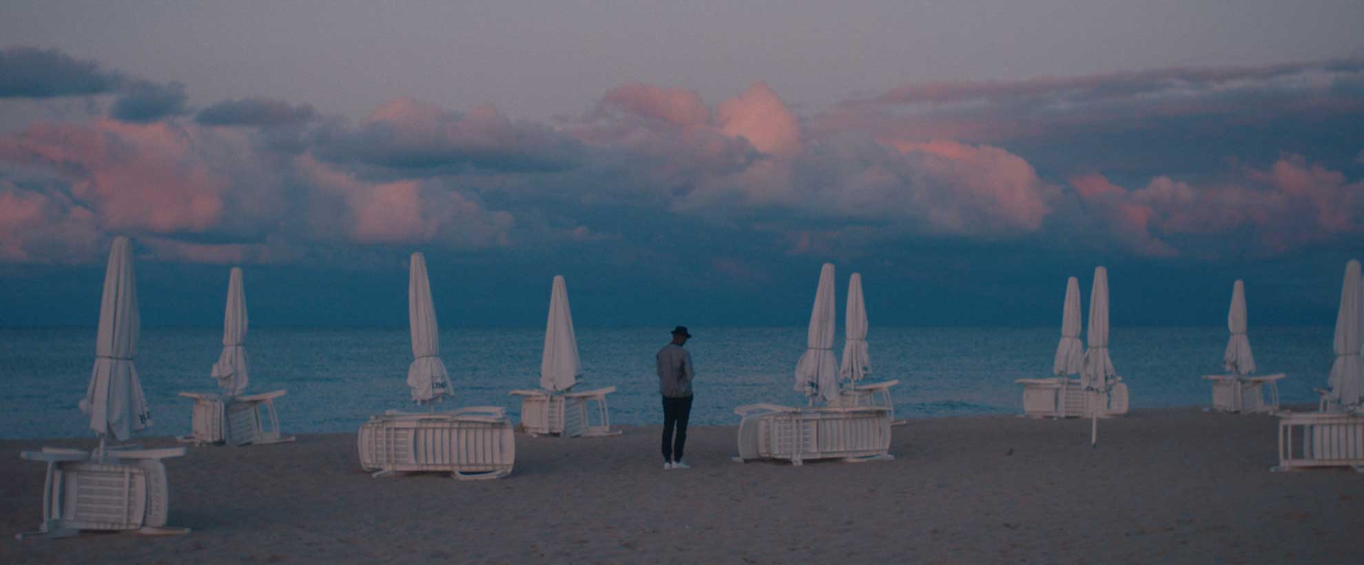 A traveller overlooking the sea and mountains in a StoryBooked production still