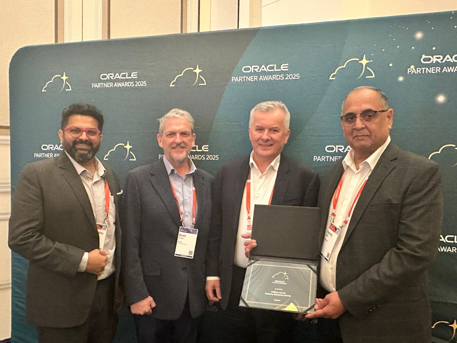 Neeraj Datta, at right, with fellow attendees holding an Oracle Partner Awards 2025 plaque