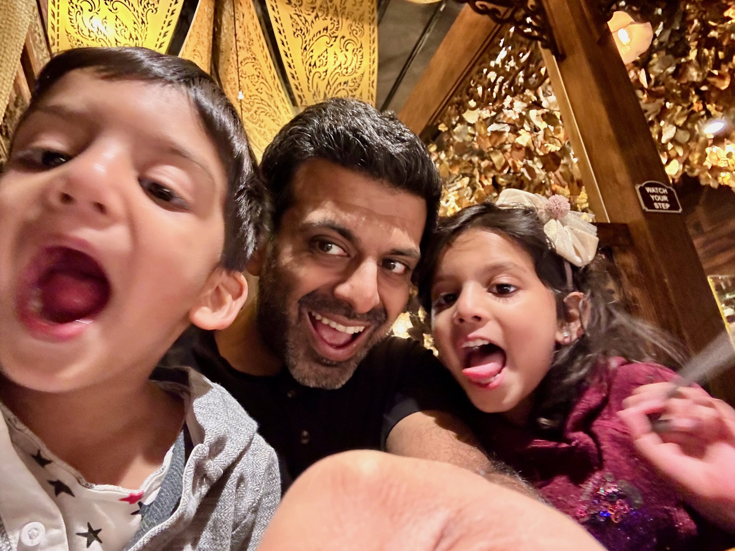 Nehal Madhani and his two children making playful faces for a family photograph