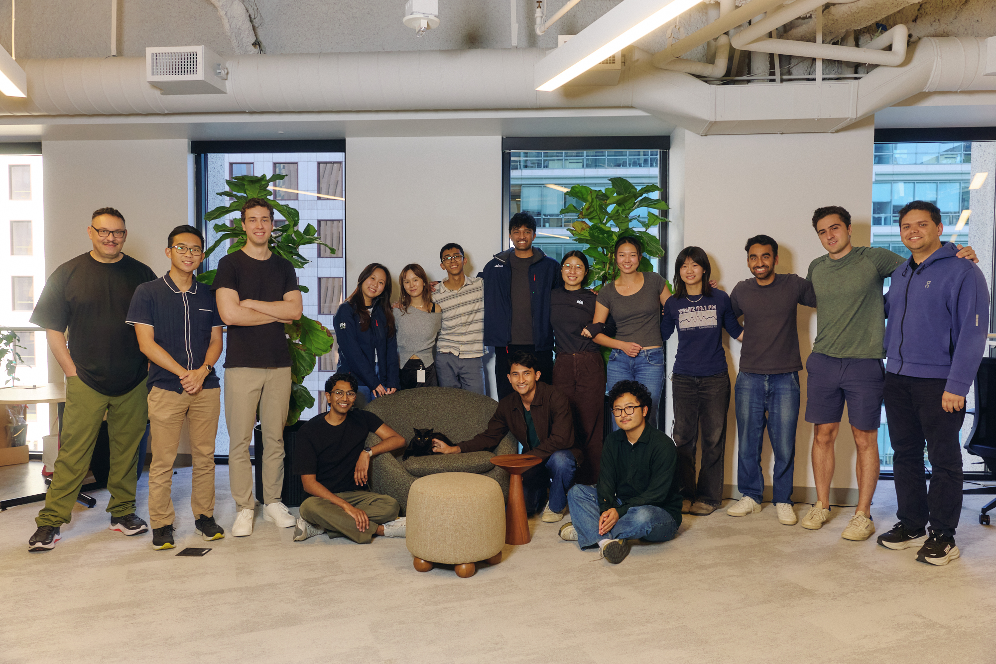The Sail Research team gathered in its office, with a black cat on a chair