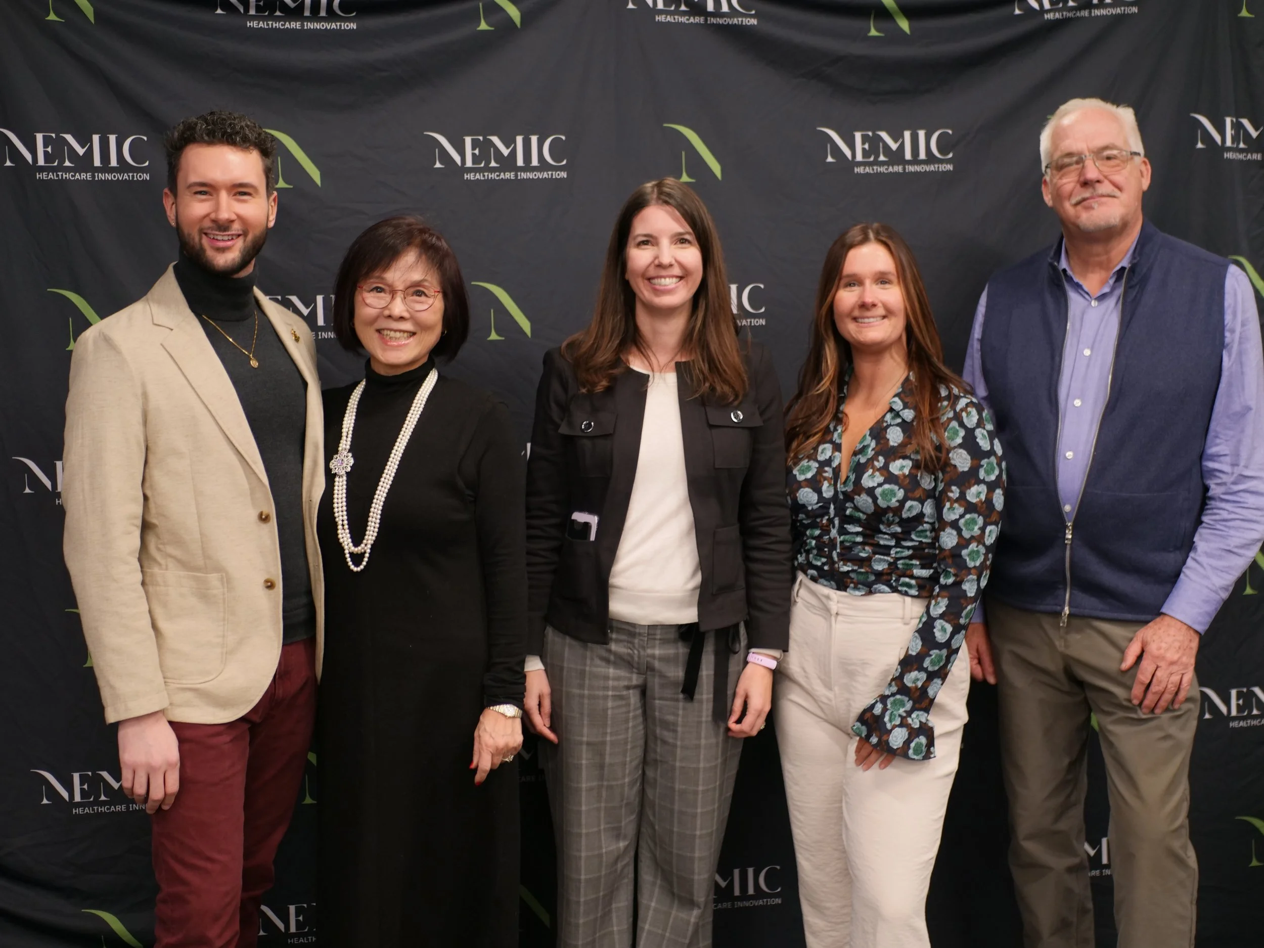 Five members of NEMIC’s team and leadership standing together