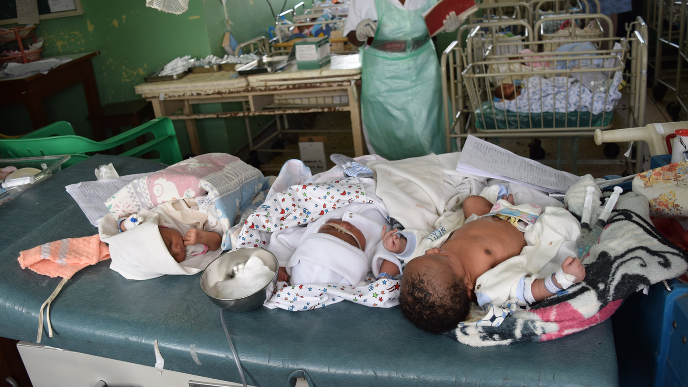 A neonatal hospital ward with several newborns and a clinician