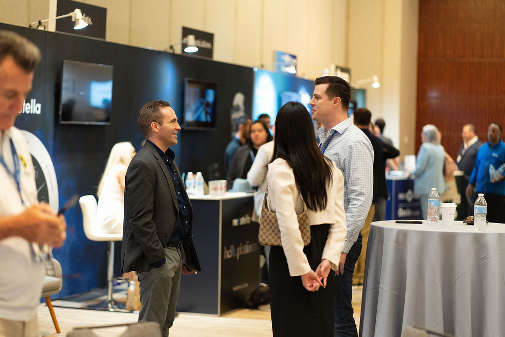 Participants talking beside Neostella exhibits at a legal technology event