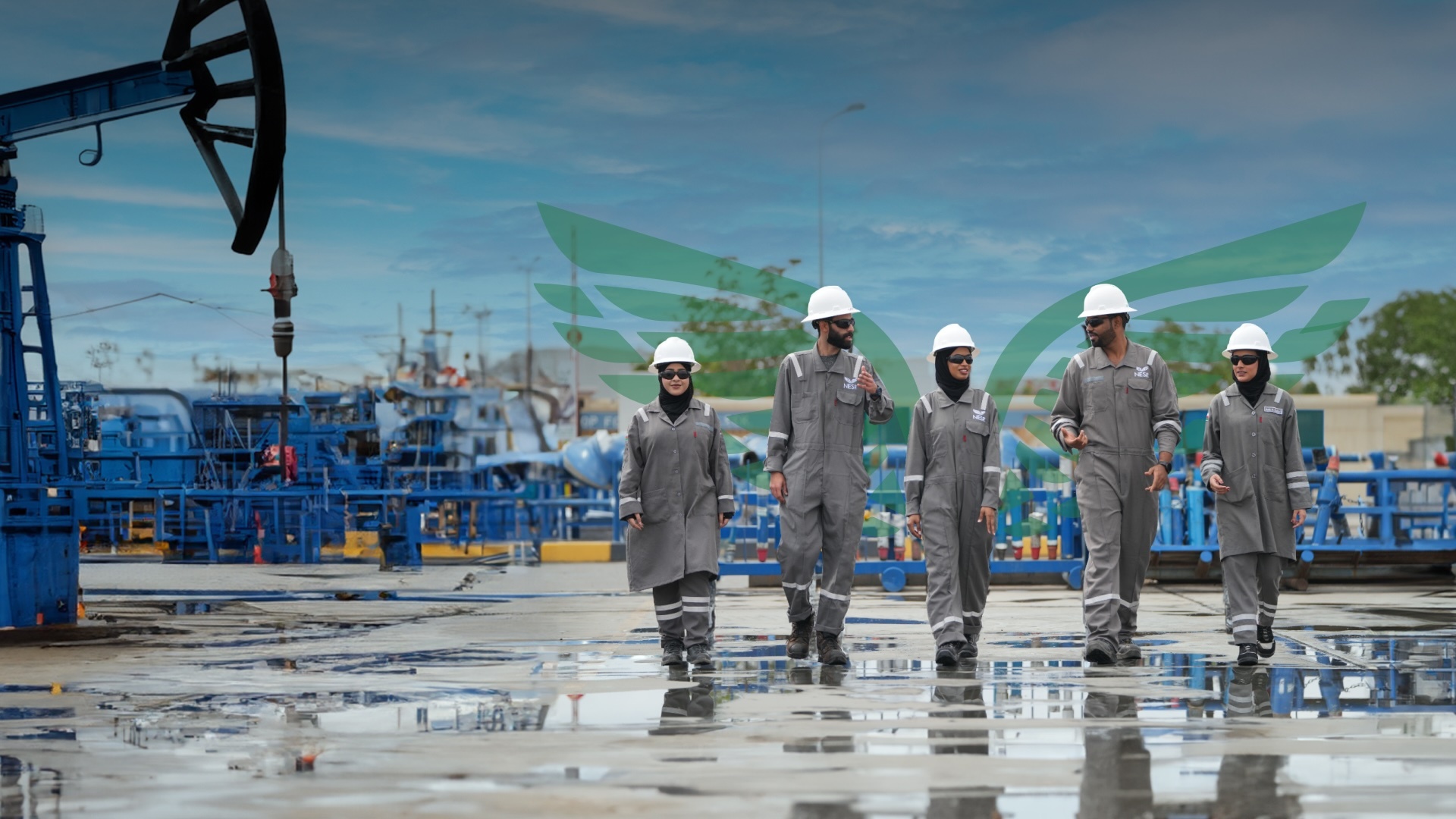NESR staff in hard hats and coveralls walking through a field facility