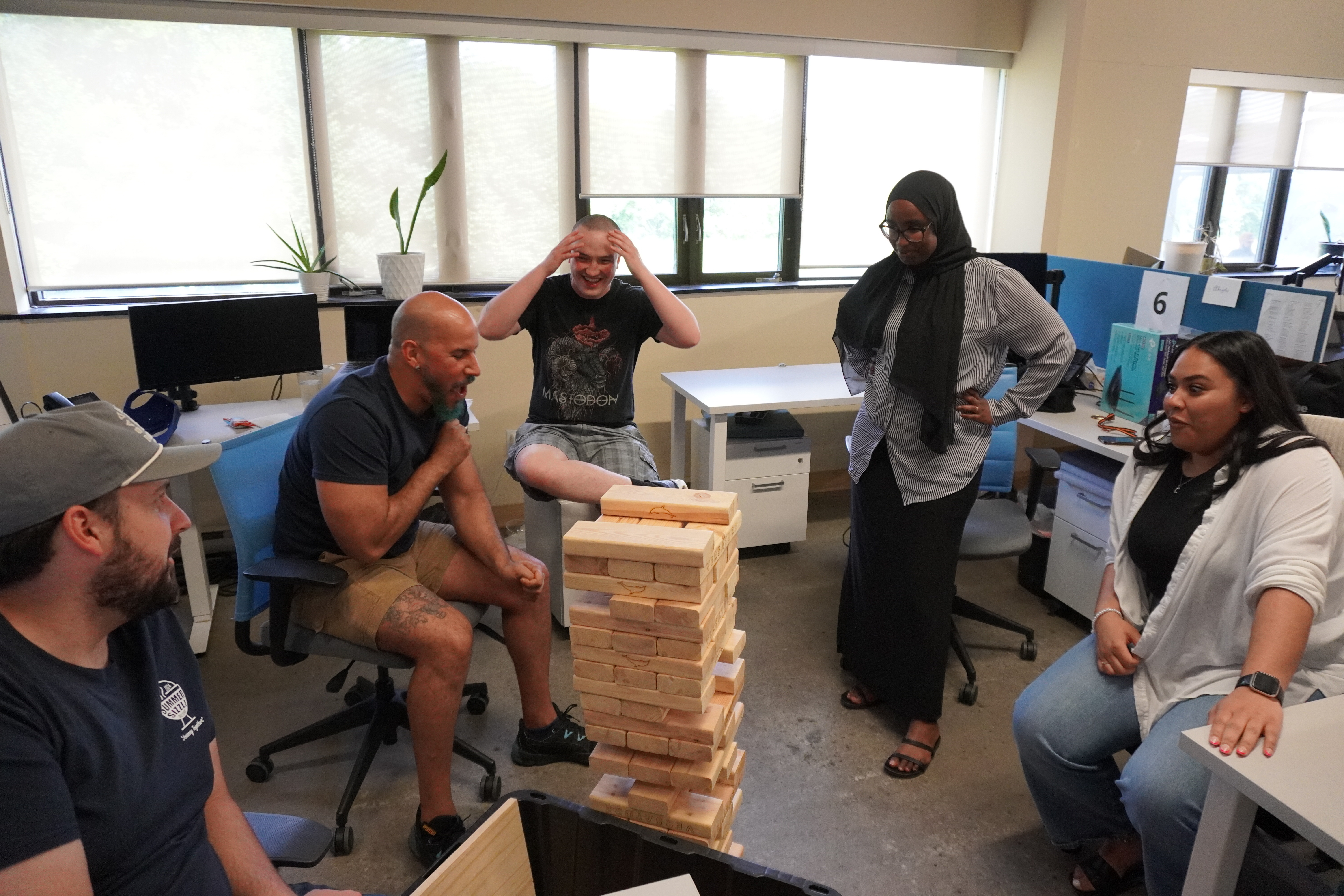Colleagues gathered around a wooden block-stacking game in a photograph published on net2phone’s About page