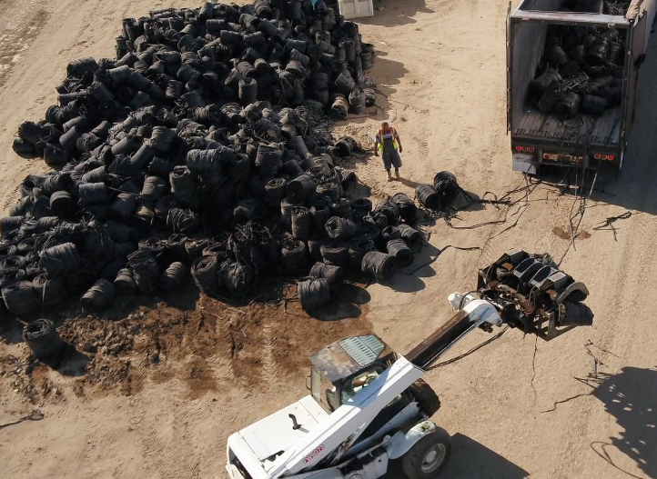 A loader places bundled used irrigation tubing into a truck for Netafim recycling