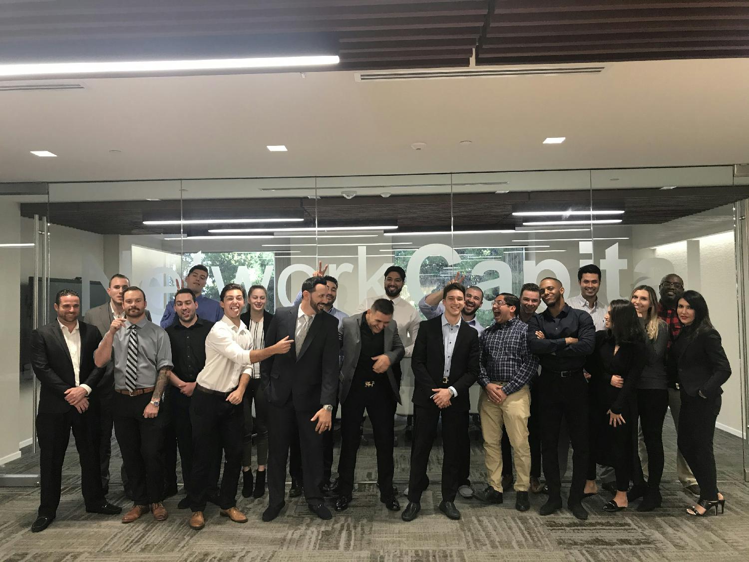 A group of Network Capital mortgage interns laughing and posing in the office