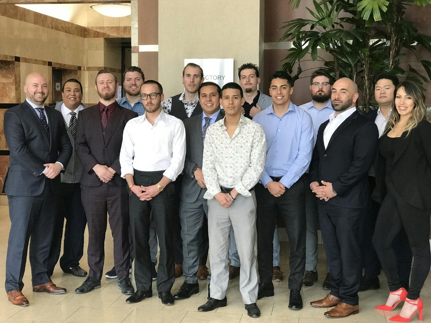 Network Capital sales team posing together in an office lobby