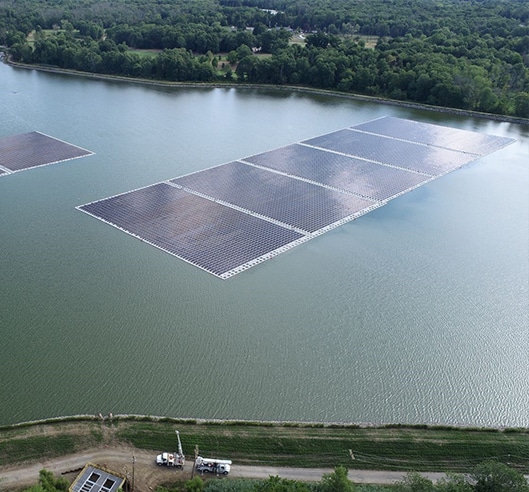 Aerial view of the Canoe Brook floating solar installation surrounded by reservoir water and trees