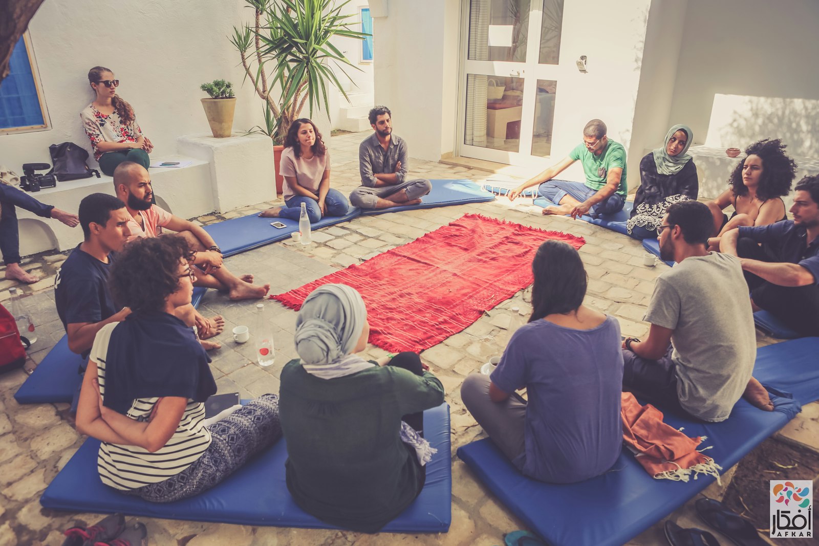 Afkar Fellowship participants seated in a circle in a courtyard