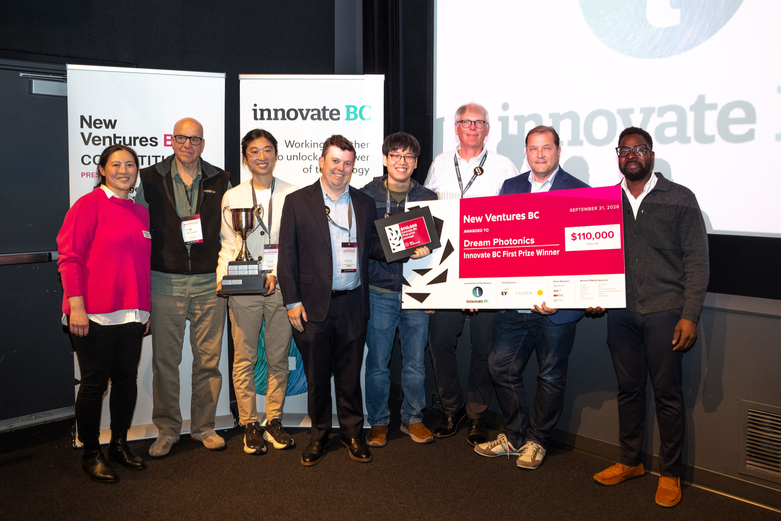 Dream Photonics representatives and competition supporters with the first-prize trophy and award board