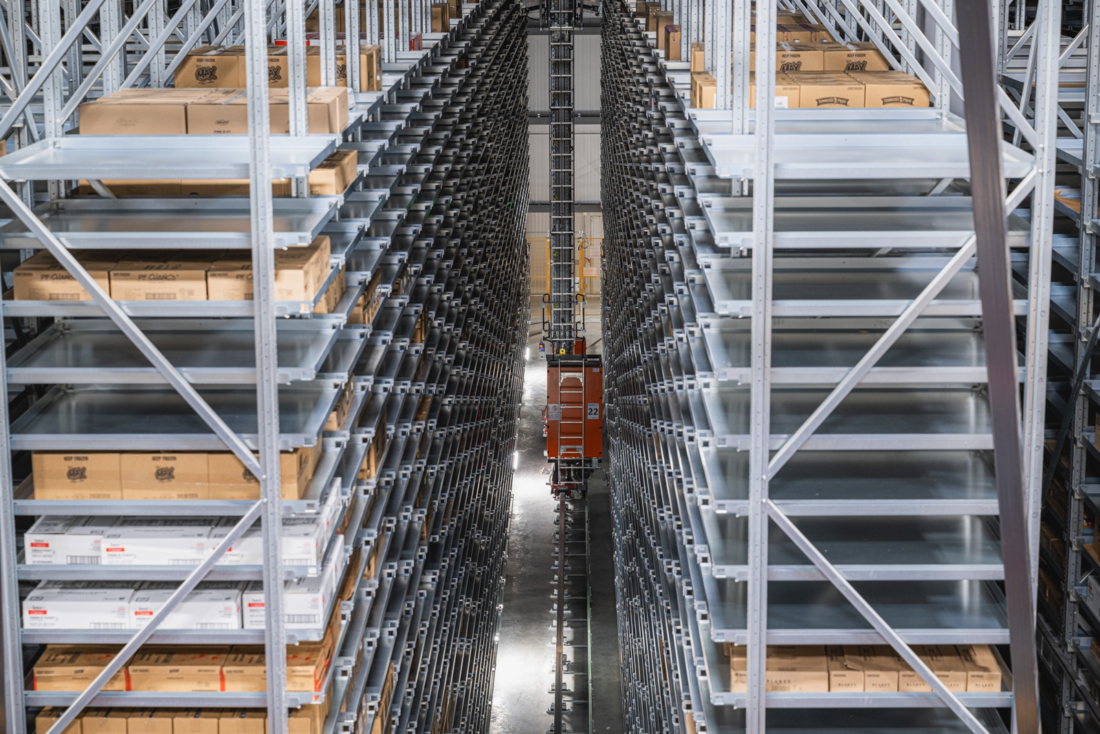 Tall pallet storage racks and an automated crane inside NewCold’s Lebanon warehouse