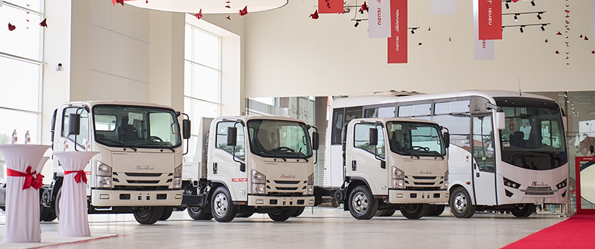 Isuzu trucks and a bus displayed inside Neweast’s Riyadh showroom