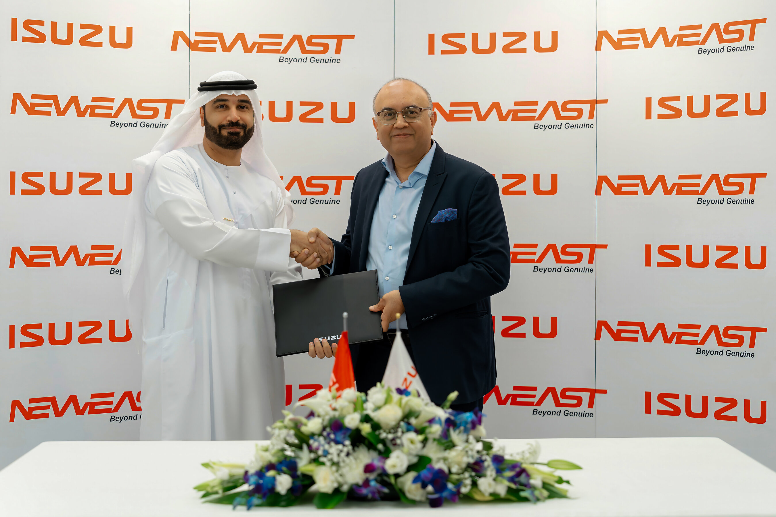 Two representatives shake hands at the Neweast and Isuzu partnership ceremony
