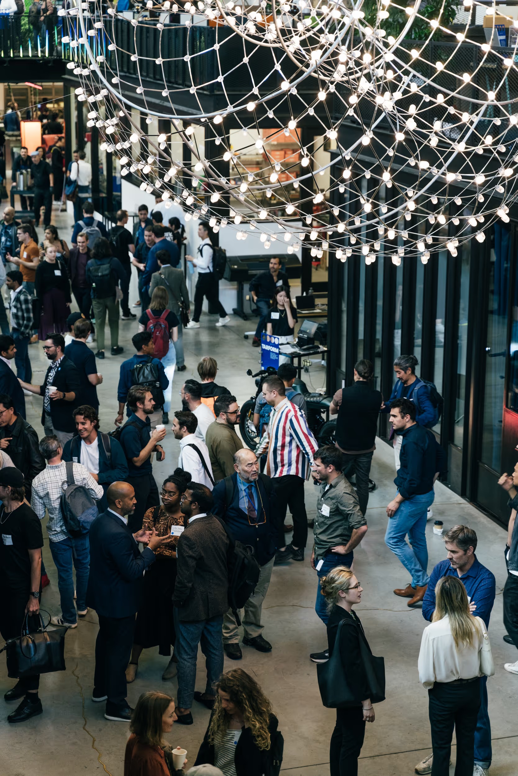 A gathering of visitors under a sculptural light installation at Newlab Brooklyn