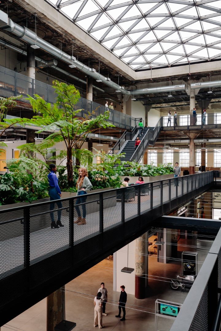 People on planted walkways beneath the skylight at Newlab’s Detroit Book Depository