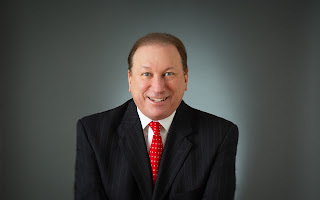 NewsUSA founder Rick D. Smith speaking at a desk