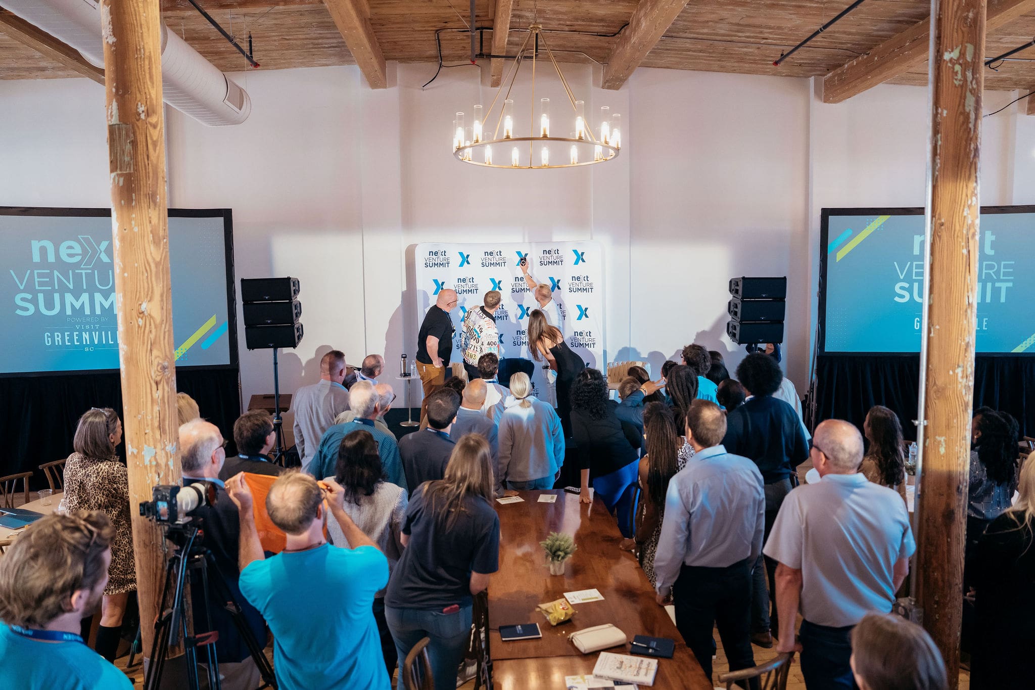 Attendees gather around the stage at a Next Venture Summit event
