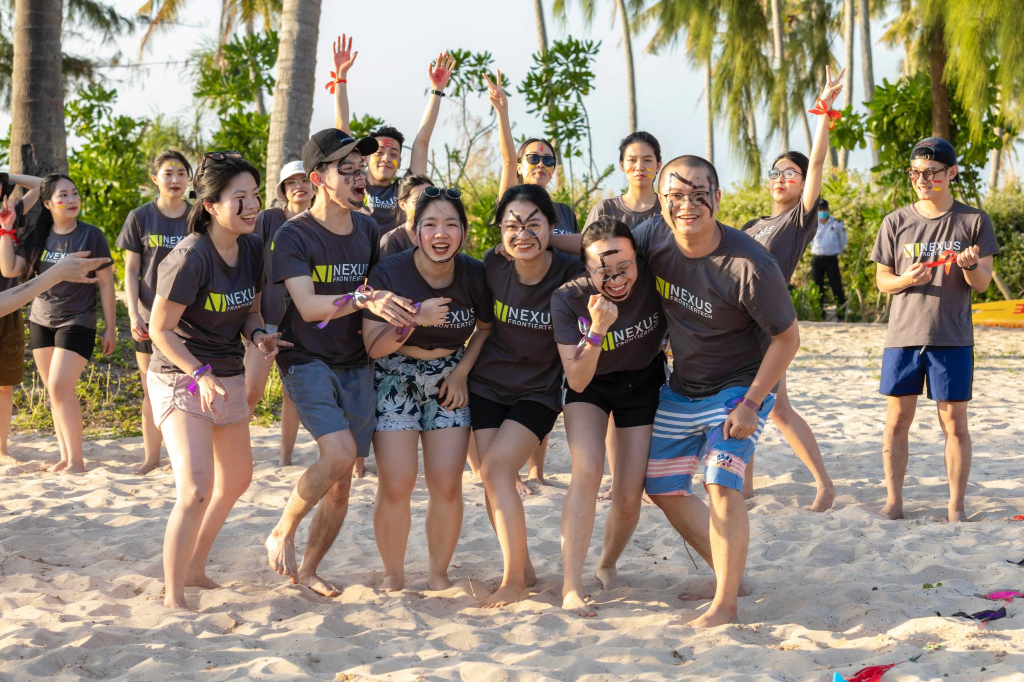 Members of the Nexus FrontierTech Vietnam team laughing together on a beach