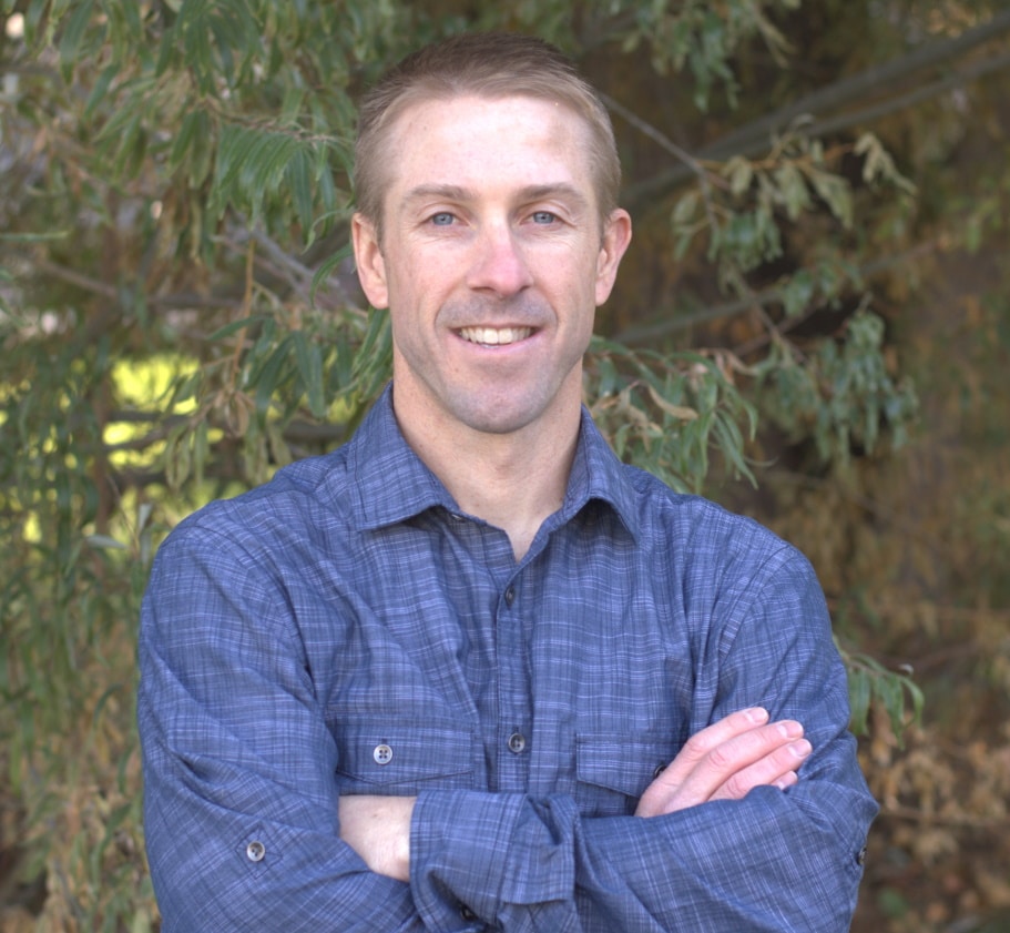 Niche Pursuits founder Spencer Haws outdoors, wearing a blue checked shirt