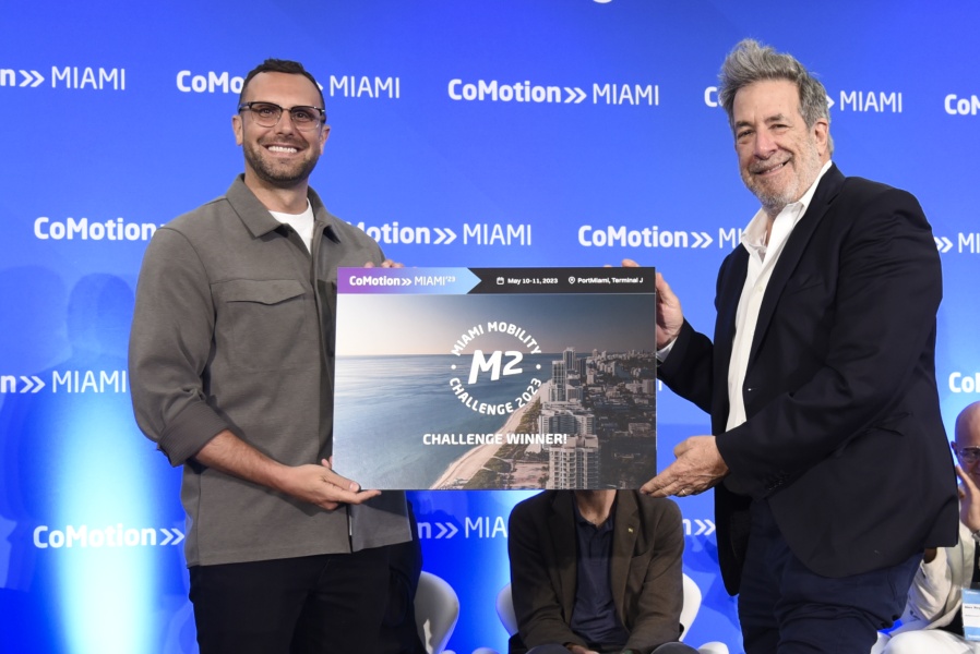 Nicholas D'Andre, left, holding the CoMotion Miami M2 Challenge 2023 winner sign