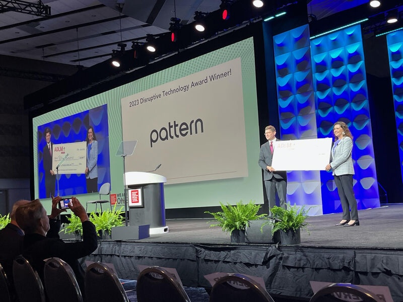 Pattern Bioscience’s 2023 Disruptive Technology Award announced on a conference stage, with presenters holding a ceremonial check.